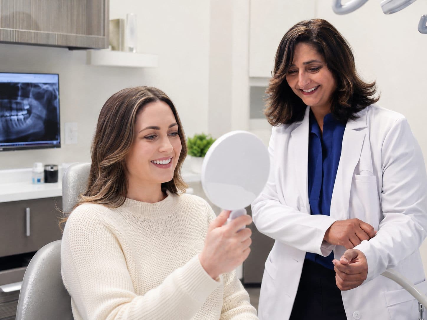 A patient admiring her smile after cosmetic treatment