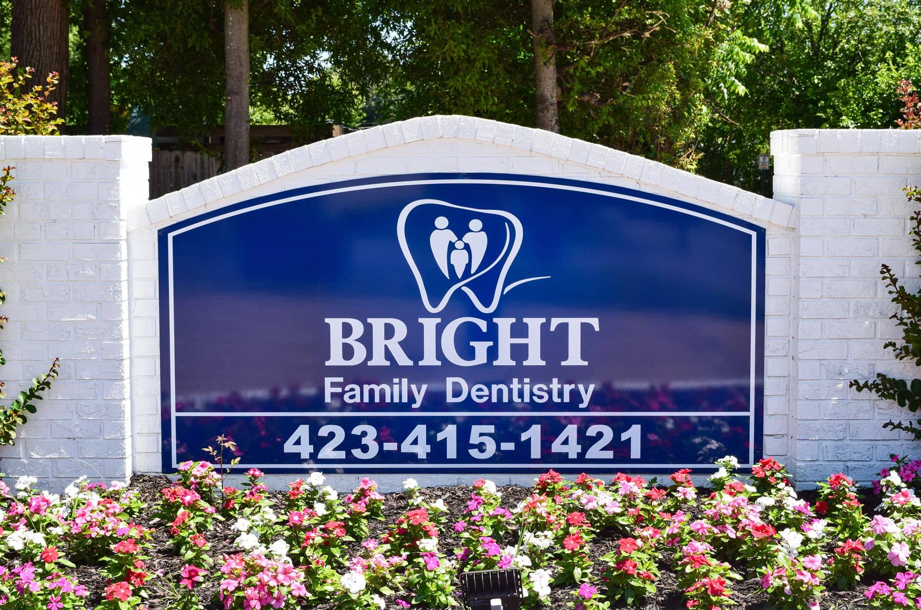 The Bright Family Dentistry monument sign surrounded by flowers